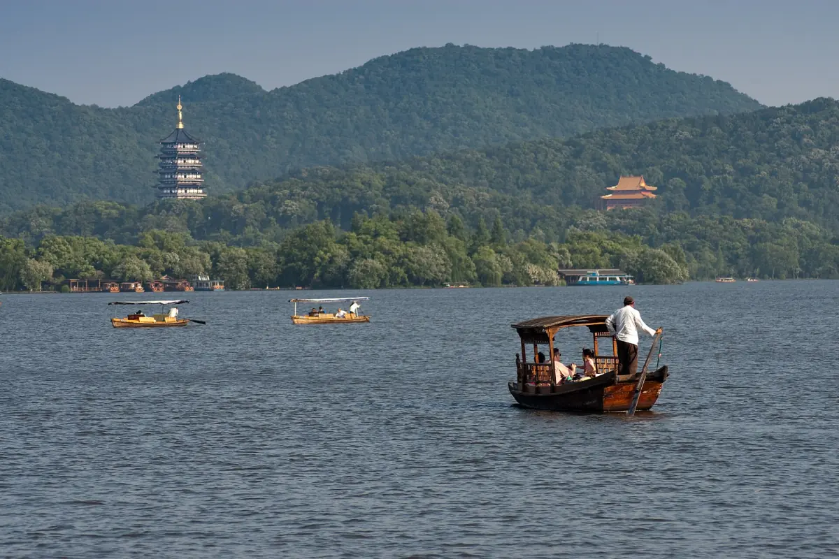 A boat on West Lake with Leifeng Pagoda on the hill
